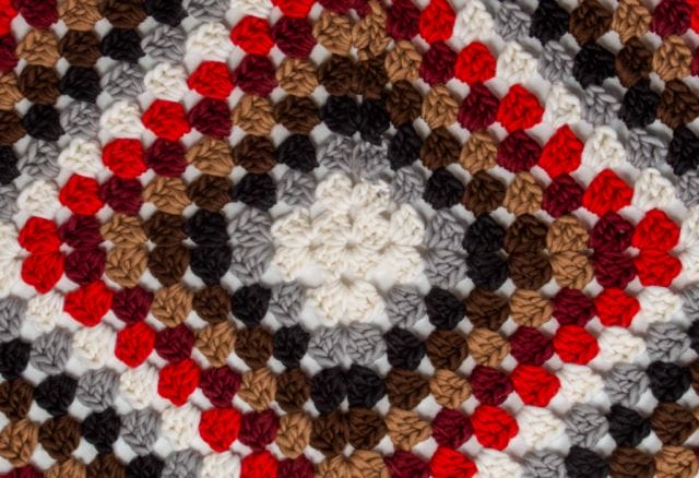 A close up of the oversized granny square stitches of the Tuff Granny Throw