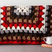 A crocheted granny square throw blanket