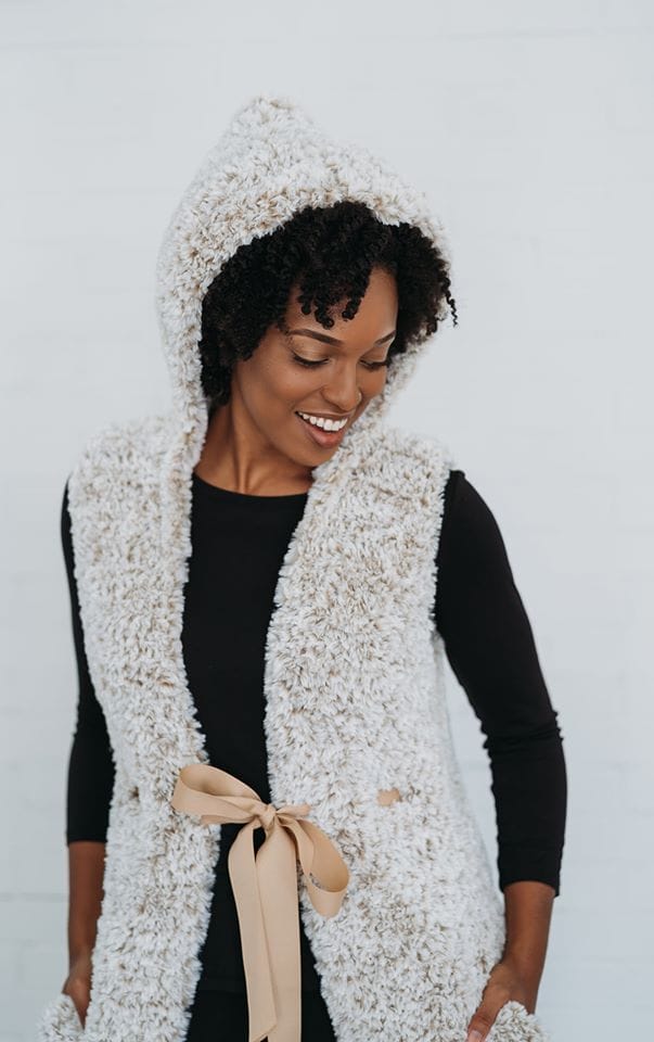 A model wears a hooded fur vest