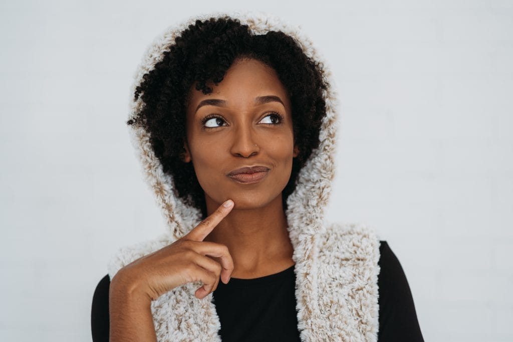 A model is shown wearing a hooded fur vest