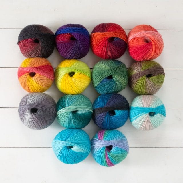 14 balls of Chroma Worsted yarn in various colors