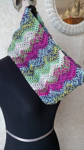 A picture of a colorful zig-zag scarf cowl on a mannequin. The Felici on the Double Cowl by Sati Glenn.