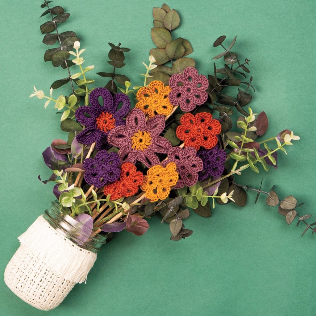 A bouquet of crocheted flowers in a jar