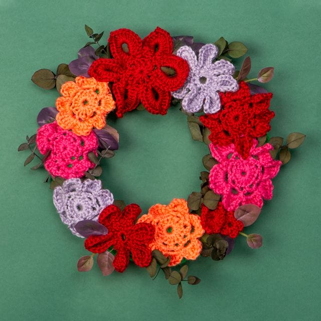 How to make a crocheted flower wreath: an image of a wreath covered in crocheted flowers