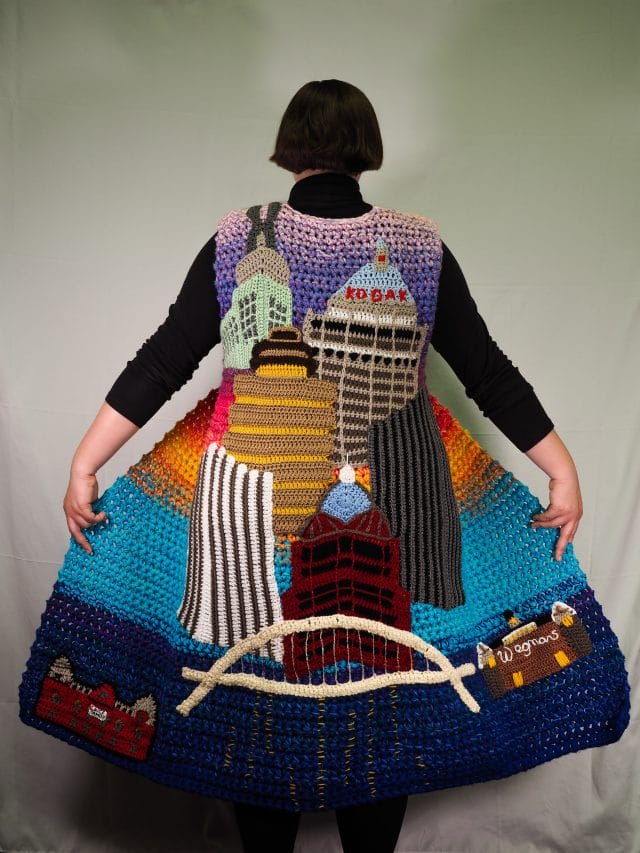 The Rochester Coat is a long vest Ashley designed featuring the buildings of Rochester crocheted on the back of it.