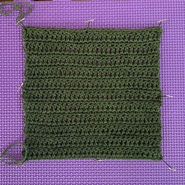 A crochet swatch on a blocking mat. Palette in Clover