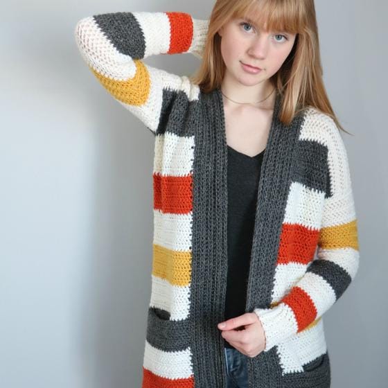 A teen girl wears a striped crocheted cardigan