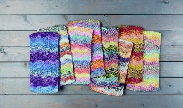 a pile of striped cowls in rainbow colors