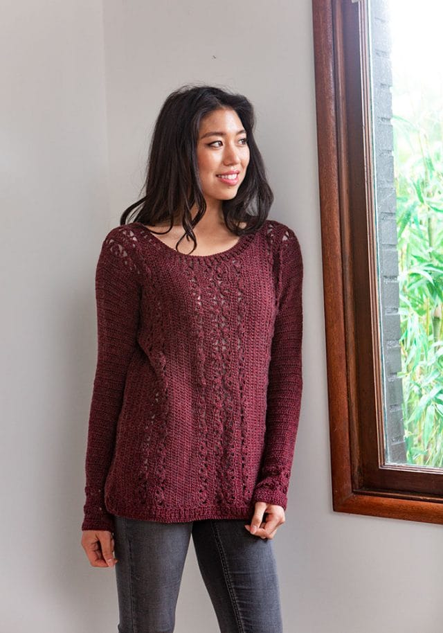 a model wears a hand-crocheted sweater in dark red