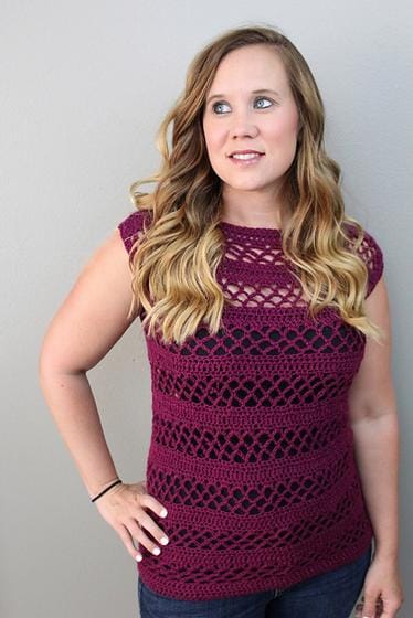 Michelle models the Magnolia Tee, a sleeveless maroon crocheted top with bands of solid crochet and bands of filigree lacy crochet