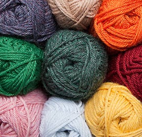 Wool of the Andes Superwash Yarn: A stack of colorful balls of yarn