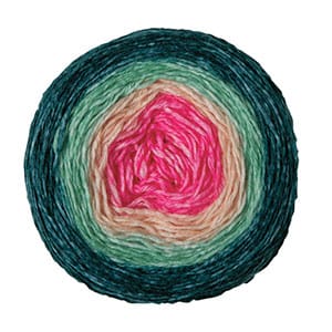 a circular cake of yarn with gradually changing colors, from dark green to light green to white to pink