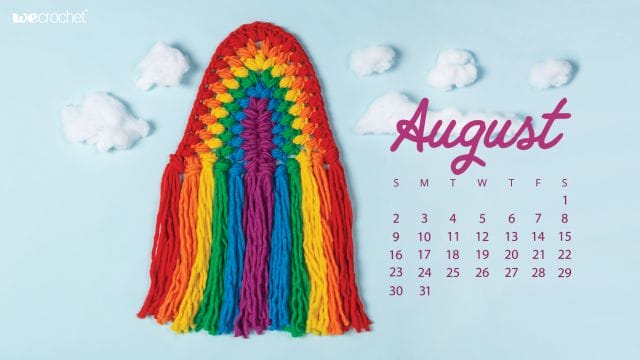 On a sky-blue background, a crocheted rainbow wall hanging, reminiscent of macrame, in rainbow colored puff stitches: red, orange, yellow, green, blue, purple. In the background, clouds made of cotton batting. On the left, an August 2020 calendar in purple.