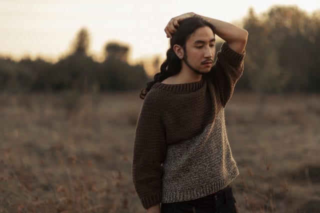Regan wearing a handmade sweater. Slow fashion is participating in creating your own wardrobe, whether through sewing, crocheting, knitting, or other methods.
