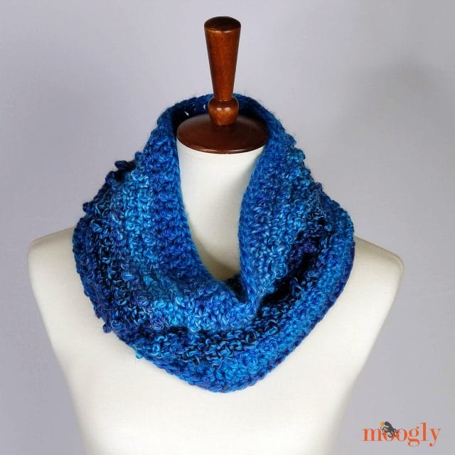 Picot Trip Cowl pattern by Moogly. A blue crocheted cowl on a dress form. 