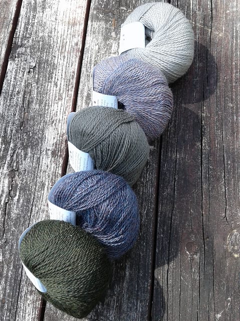 Five balls of Palette yarn in blue-grays.