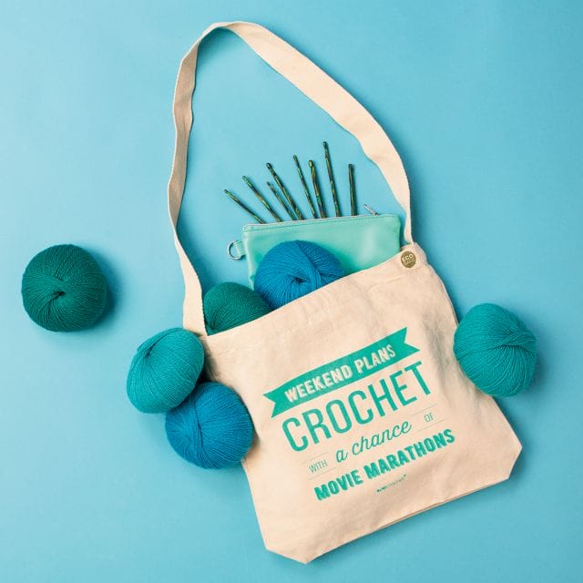 10 Thrifty Crochet Tips from the WeCrochet Blog at crochet.com. This photo shows: a blue background with a canvas crochet bag filled with blue yarn and a zip pouch with crochet hooks.