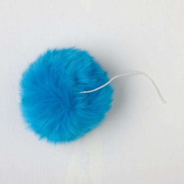 A fur pom pom with a string to attach
