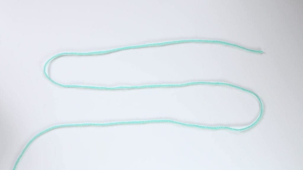 Begin by making yarn into an S-shape.