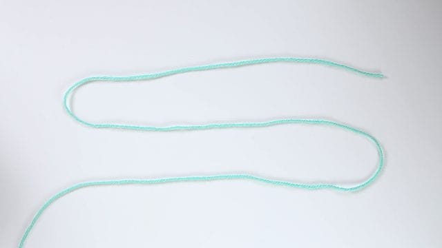 Begin by making yarn into an S-shape.