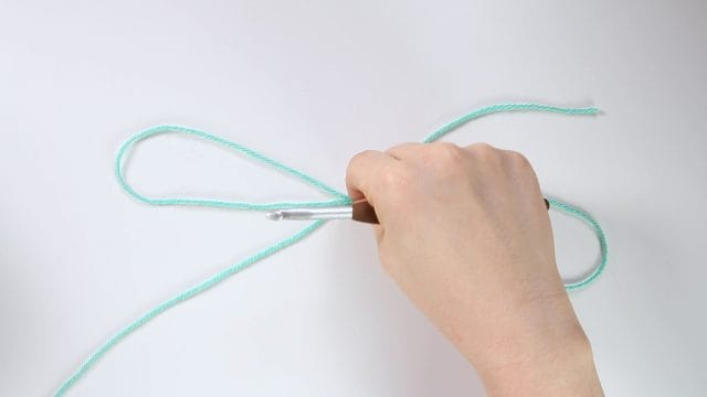 Pinch center of S to pick up 3 strands of yarn.