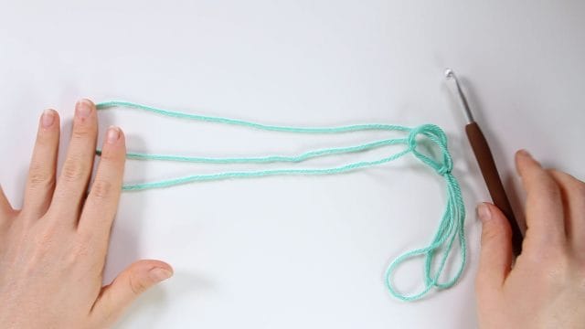 Pull a length of yarn off the cake of yarn to make a long loop. Gather 3
strands of yarn together so that the single strand winds off cake and joins 2 strands of the new long loop.