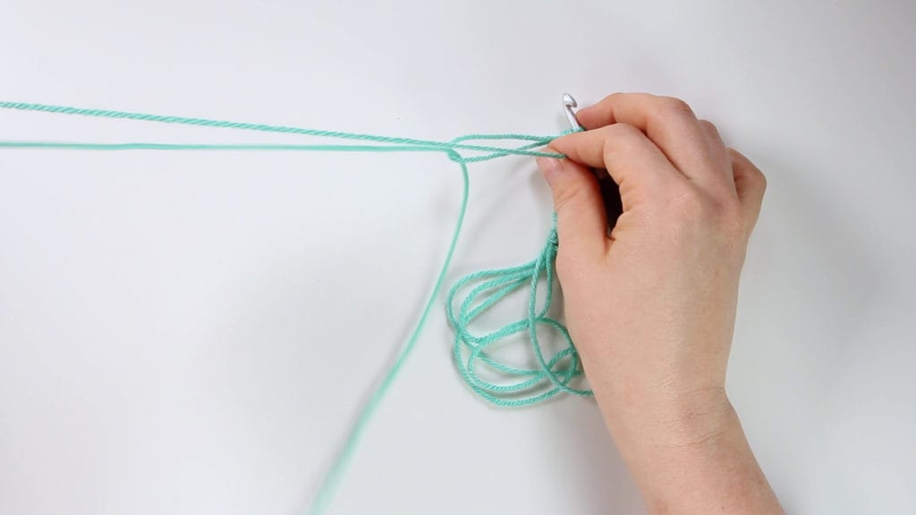 pull the single strand through end of loop to make a new long loop and allow single strand to join it as you crochet. This image shows pulling the loop long.