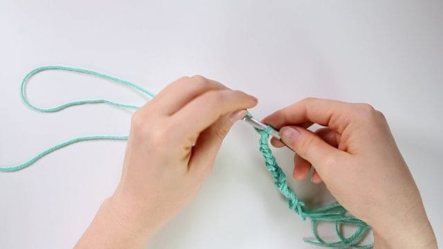 Chaining in crochet, using the triple strand method.