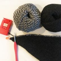 two balls of yarn + a partially-completed crochet wrap