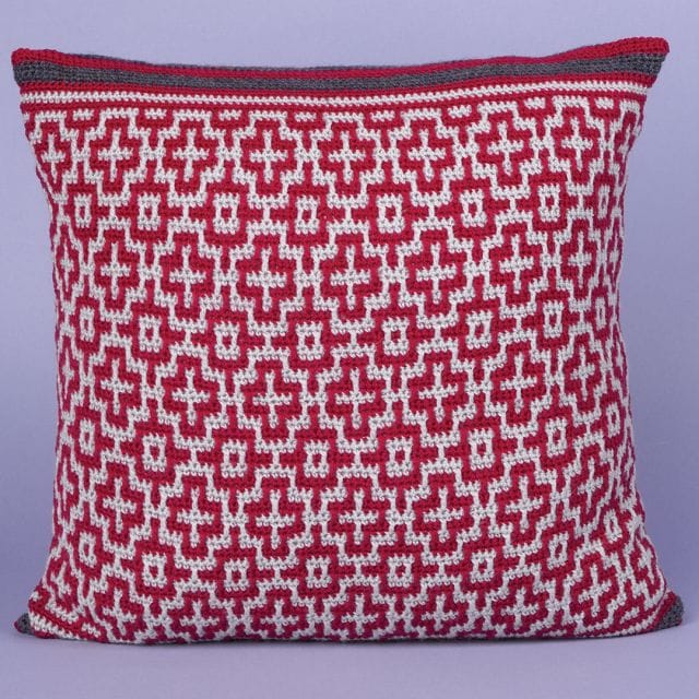 Mosaic crochet pillow with a geometric cross pattern