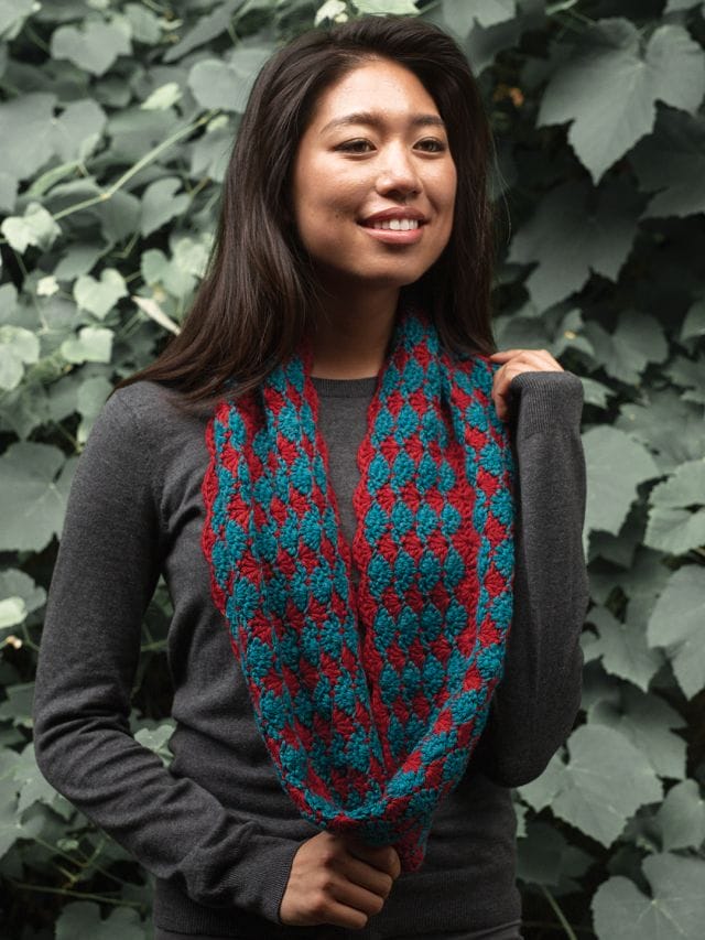A model wears the Yuletide Cowl, a crochet cowl