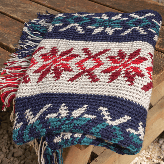 A crocheted blanket with a Nordic snowflake motif