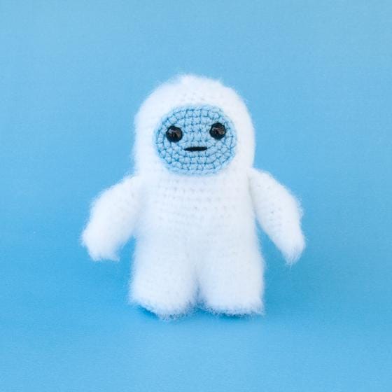 Crocheted yeti with white fur and a blue face