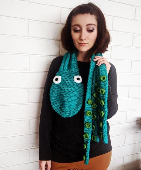 A woman wears a crocheted octopus scarf