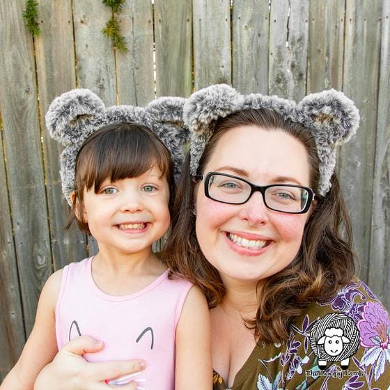 A mom and daughter wear furry bear ears headbands crocheted from Fable Fur