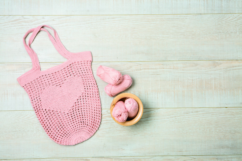 Filet Crochet Market Bag: A pink crocheted bag with a heart on it, along with some pink yarn in a yarn bowl