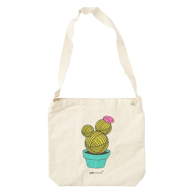 A canvas tote bag with a graphic of a cactus made of yarn balls printed on it