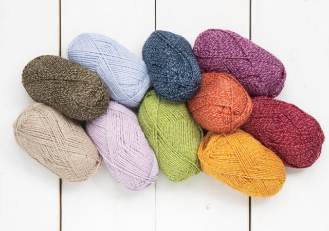 A colorful yarn spill featuring brightly colored and neutral shades of alpaca & cotton blend yarn, Kindred.
