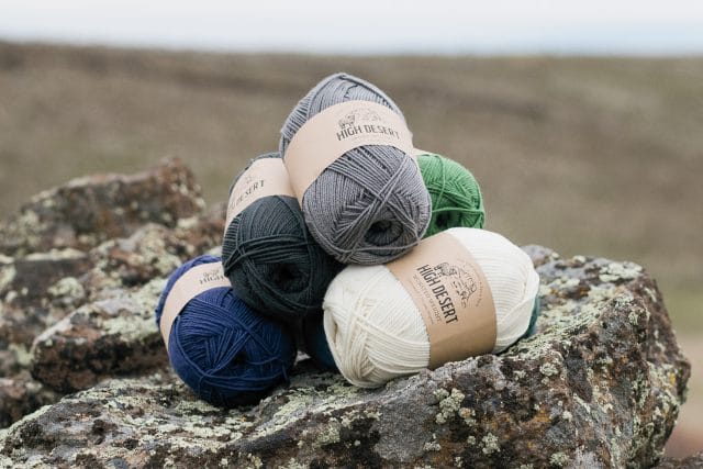 WeCrochet High Desert yarn - several balls stacked on a rock in Oregon's High Desert