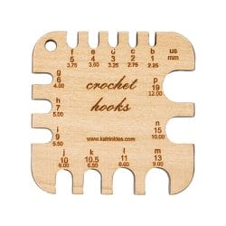 Mini Crochet Hook Sizing Tool: A wooden rectangle with notches labeled for each different size of crochet hook