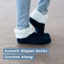 A pair of feet wearing crocheted slippers with a fur cuff. Text that says "Join the Summit Slipper Socks Crochet Along"